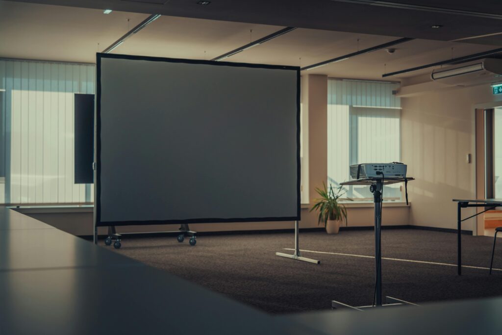 Spacious modern office interior featuring a projector and screen for presentations.